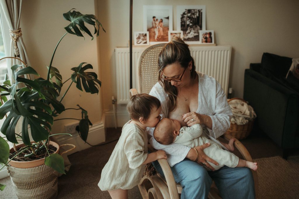 portrait photographer cornwall baby being breastfed by mum while being photographed at a family session at home