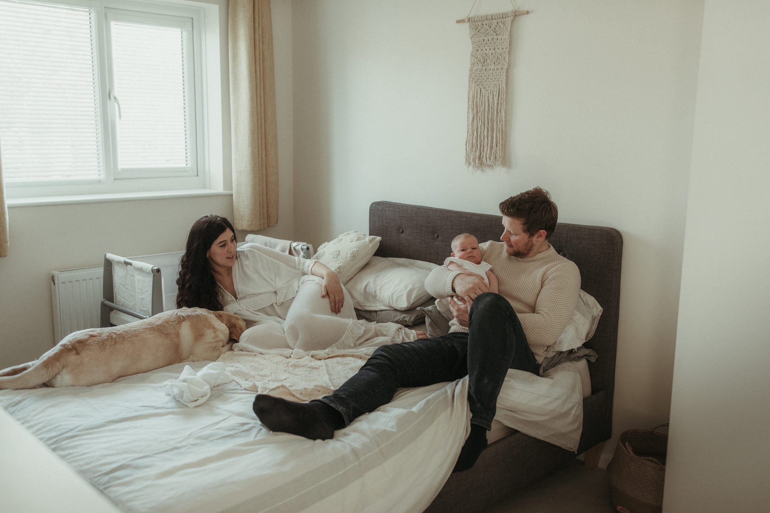 Family lie together on bed with newborn Maternity and Newborn Photographer Devon 