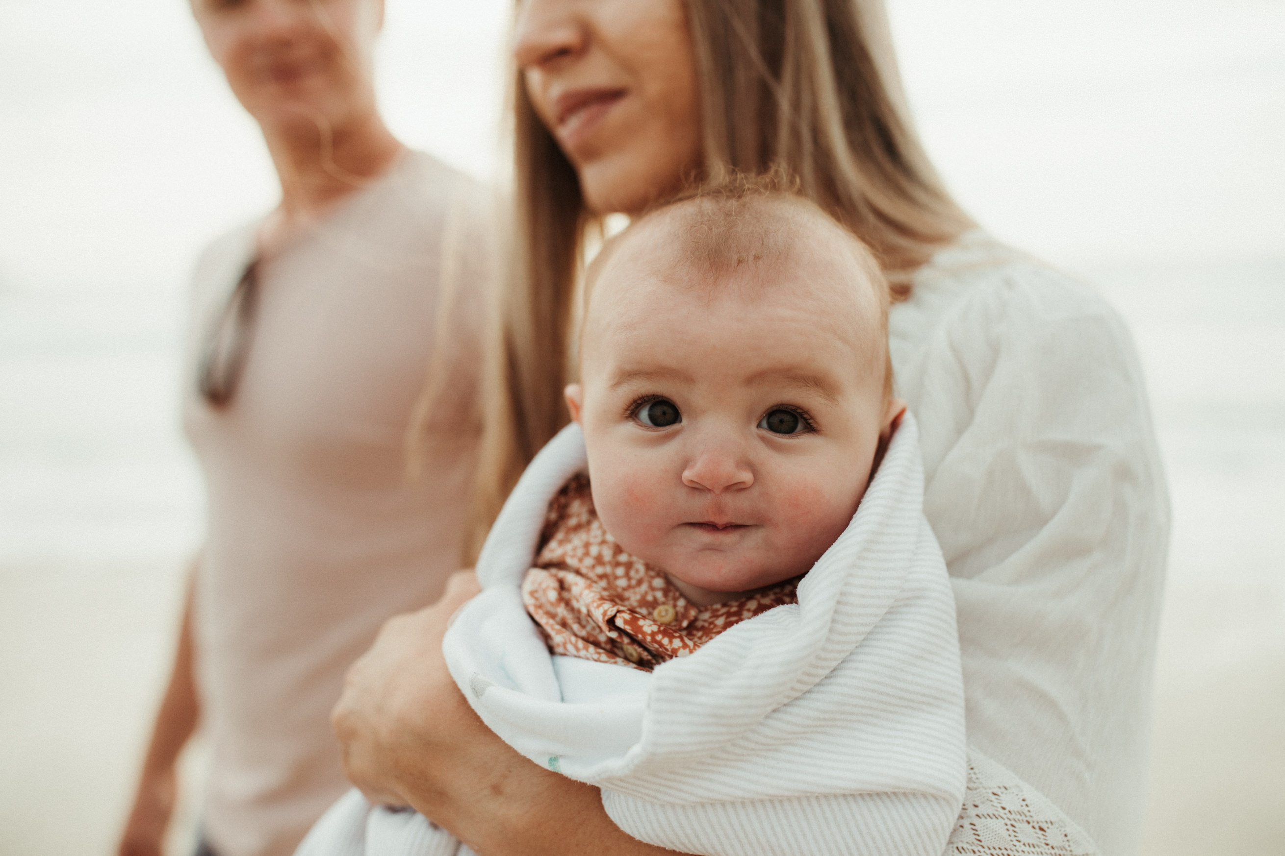 baby wrapped in blanket looks at camera